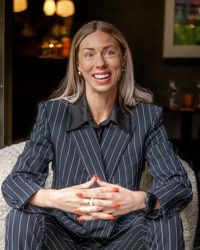 Beatrice Gustafsson, processjurist, sittande i en fåtölj i kritstrecksrandig kostym.